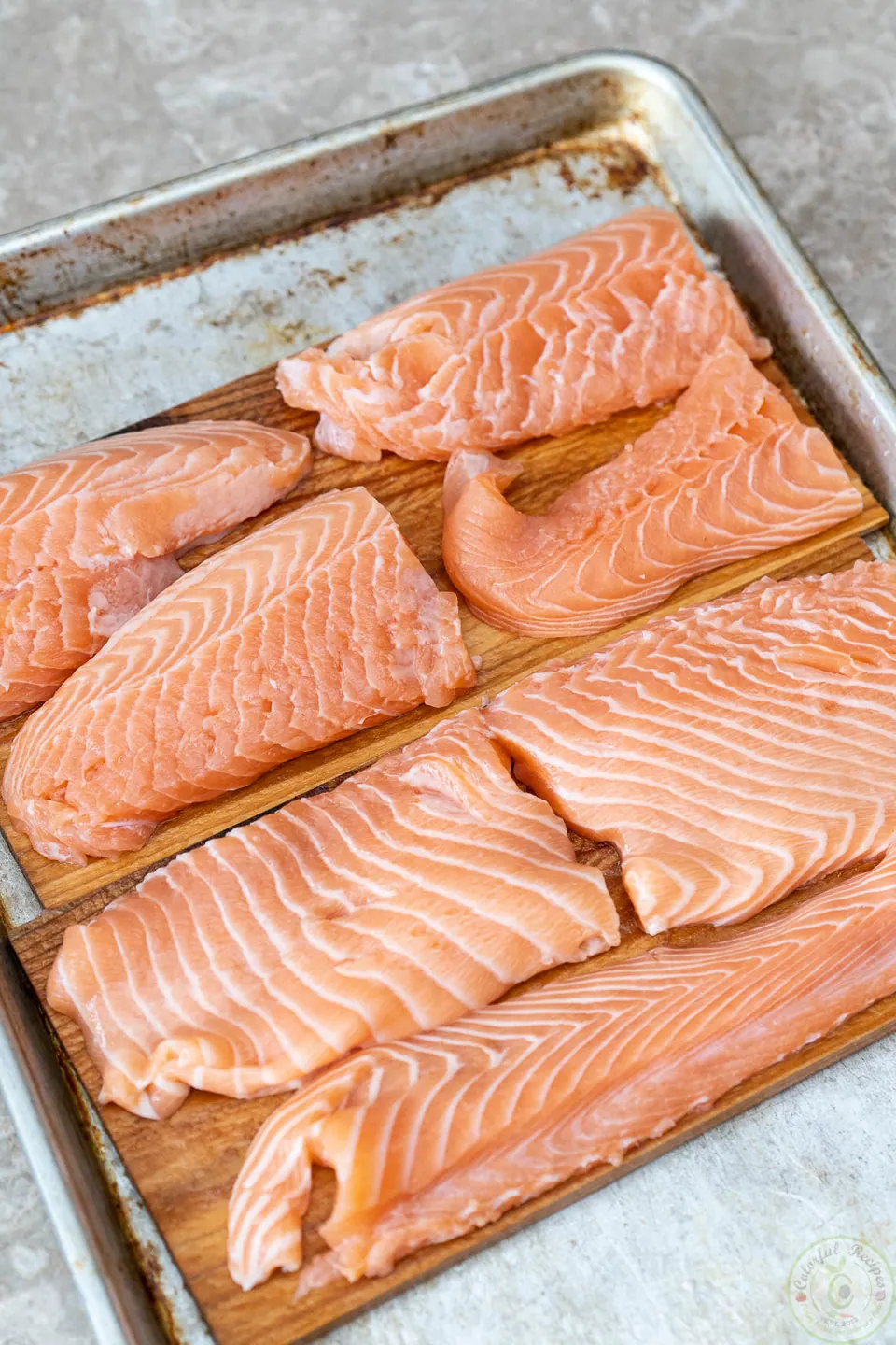 Salmon portions arranged on cedar planks before seasoning