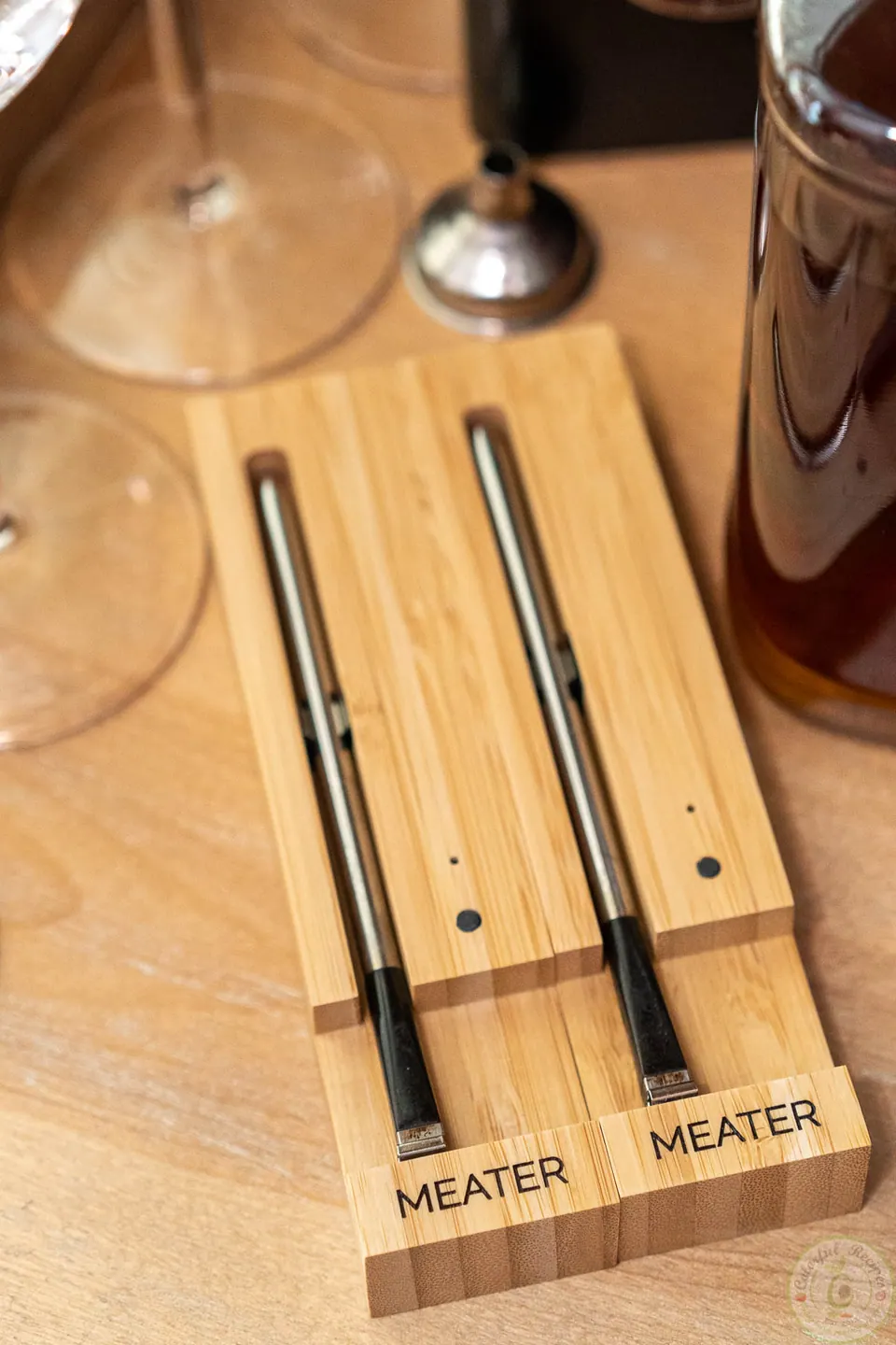 Two MEATER wireless thermometers in their bamboo charging dock