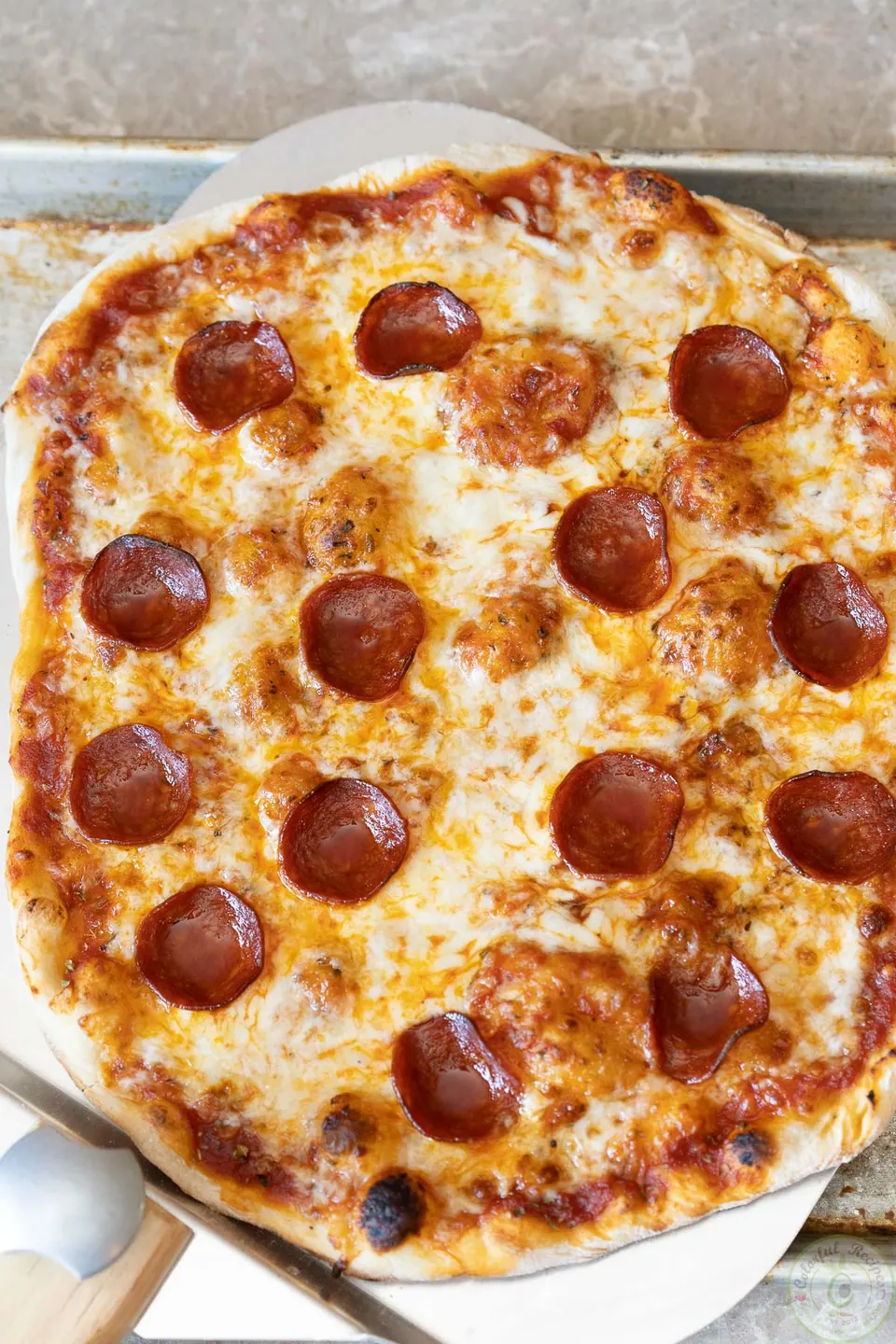 Classic pepperoni pizza with melted mozzarella on a pizza peel