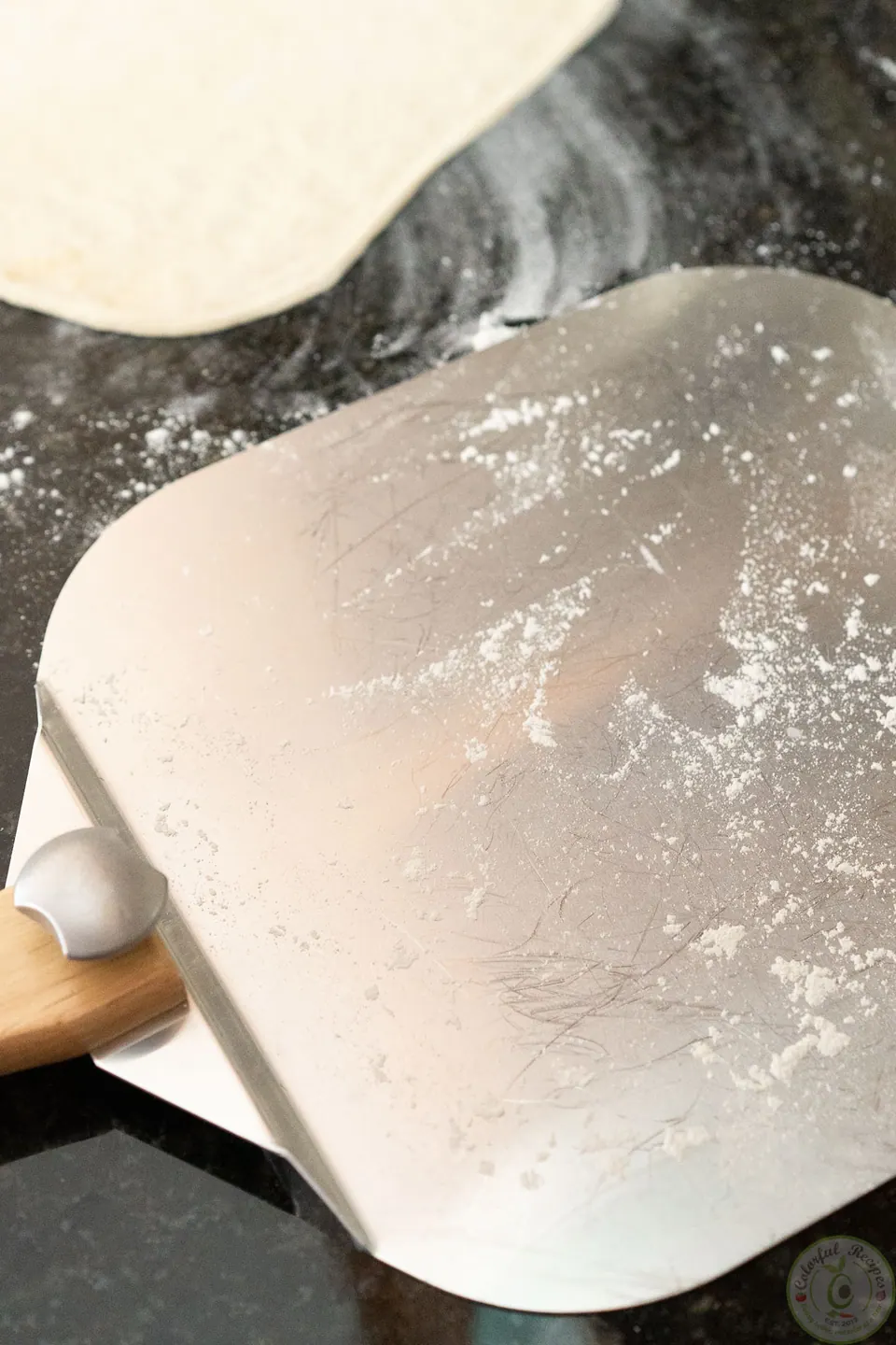 Pizza peel dusted with flour for sliding the pepperoni pizza