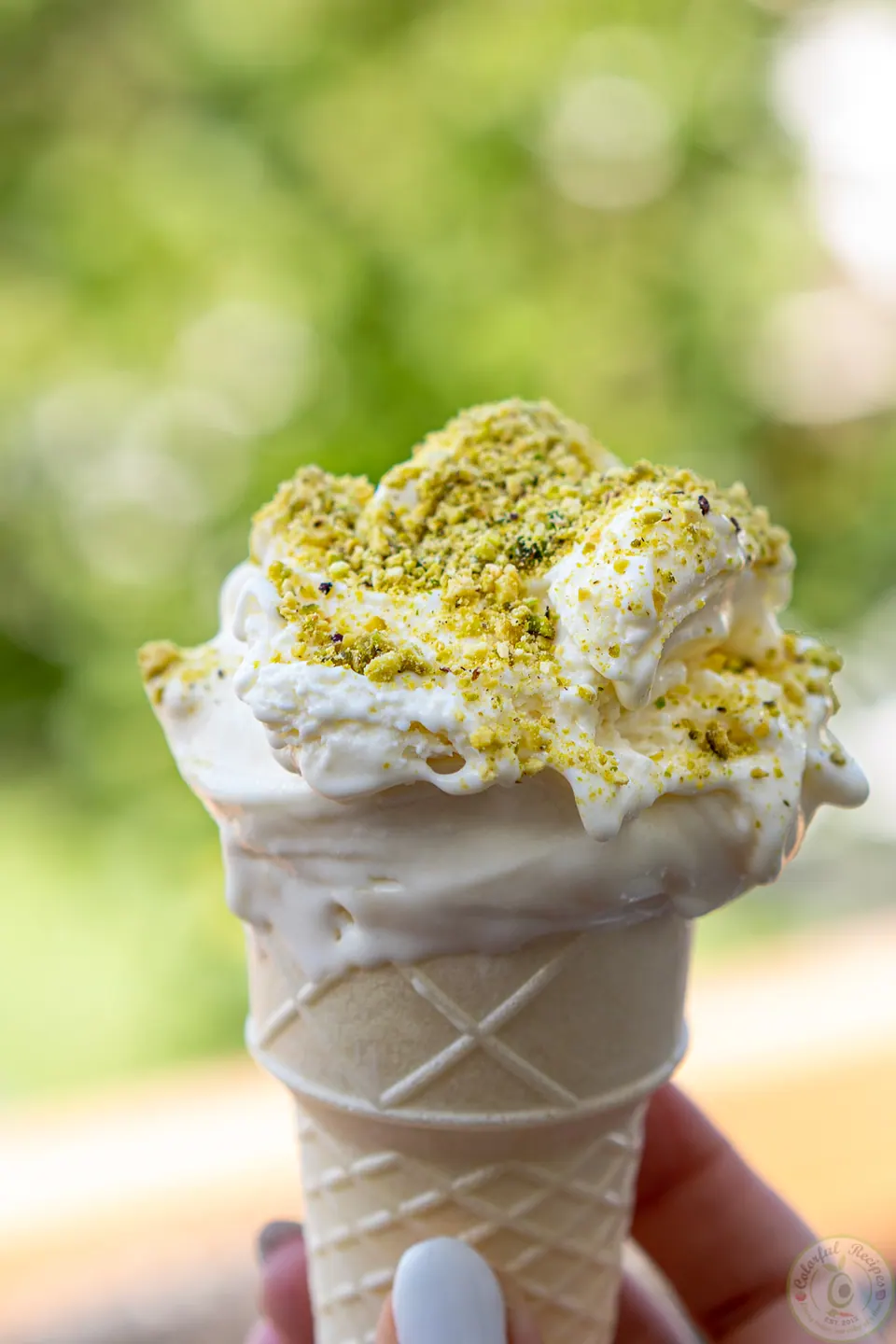 Cone of Lebanese milk ice cream booza topped with crushed pistachios