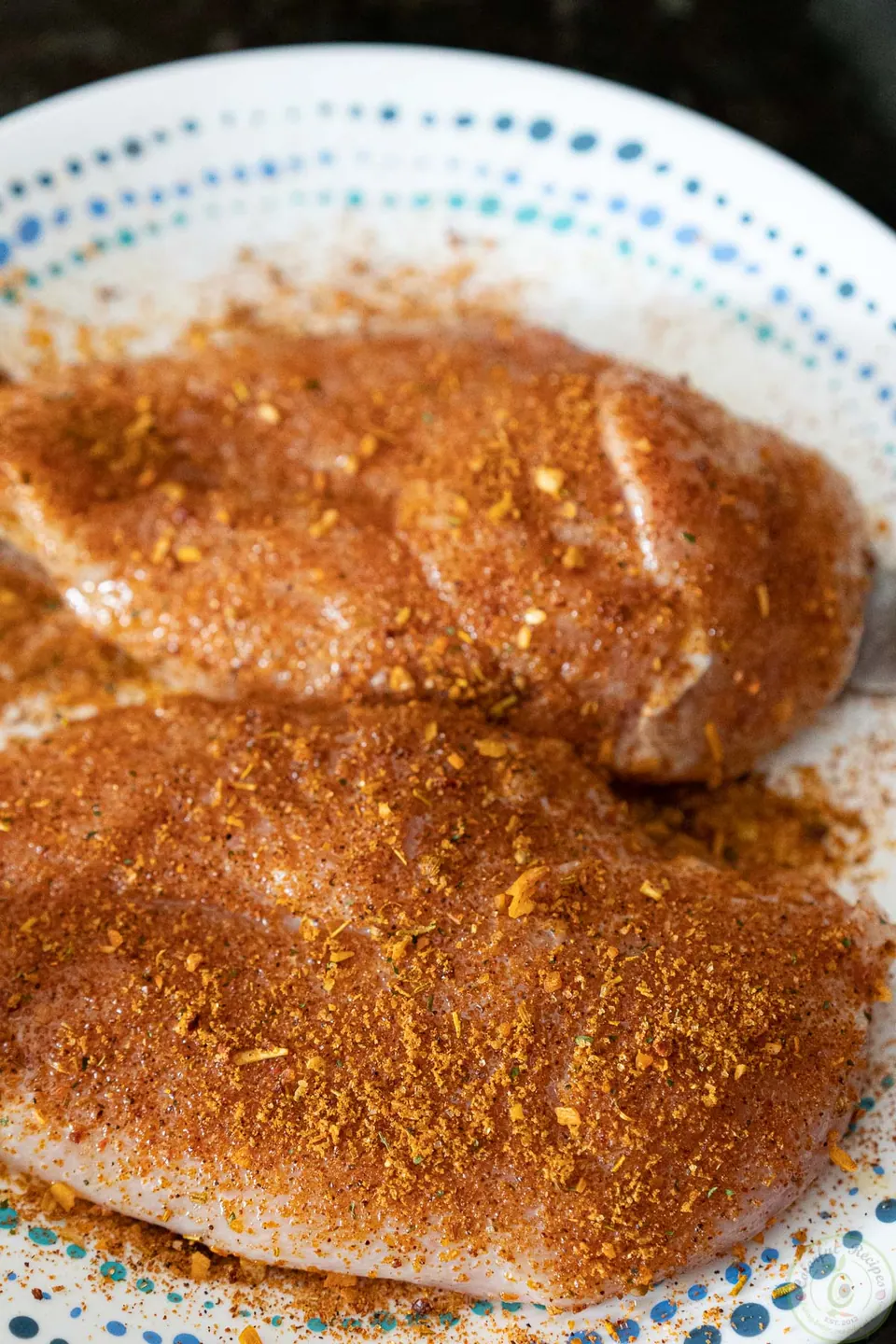 Raw chicken breasts coated in salmon seasoning for this grilled chicken breast recipe