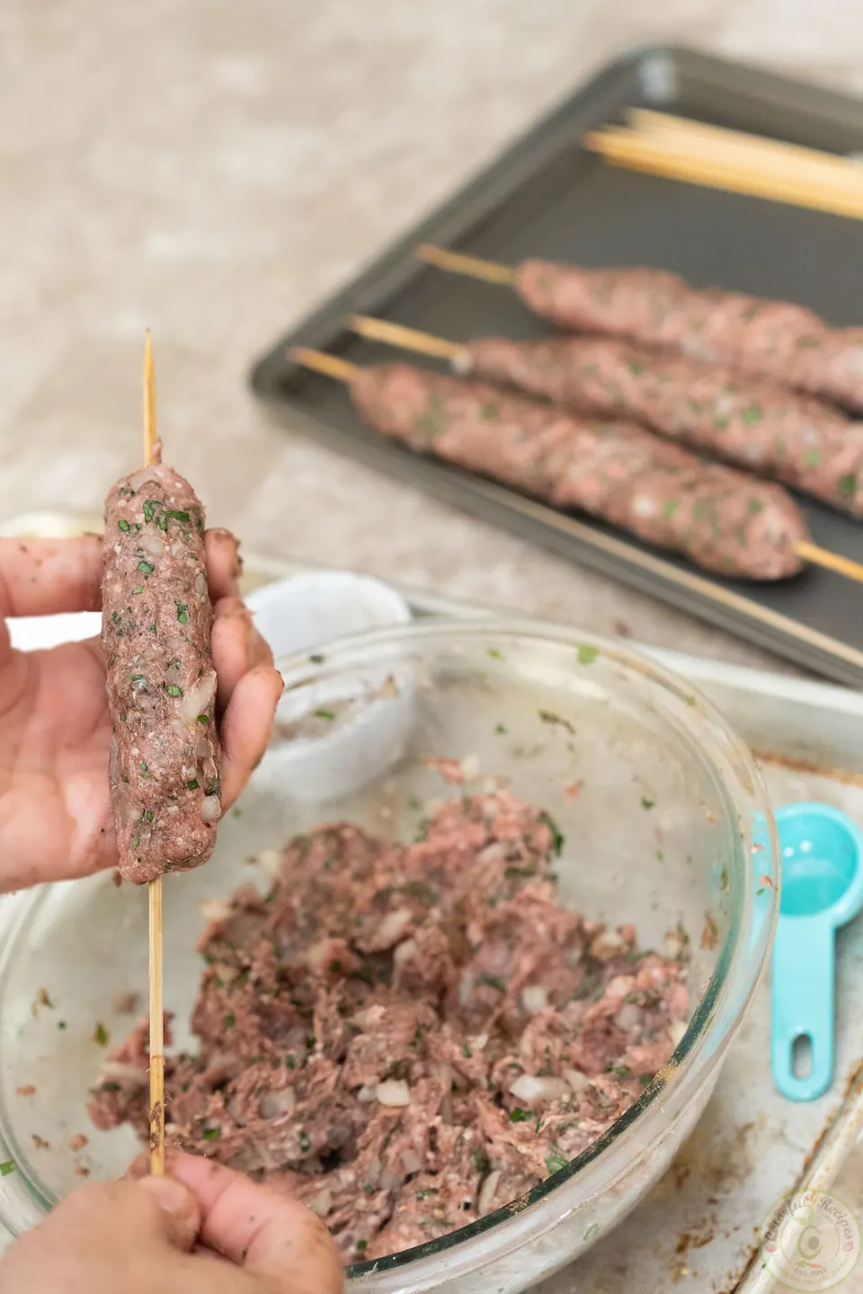Shaping the lamb kafta mixture around a wooden skewer