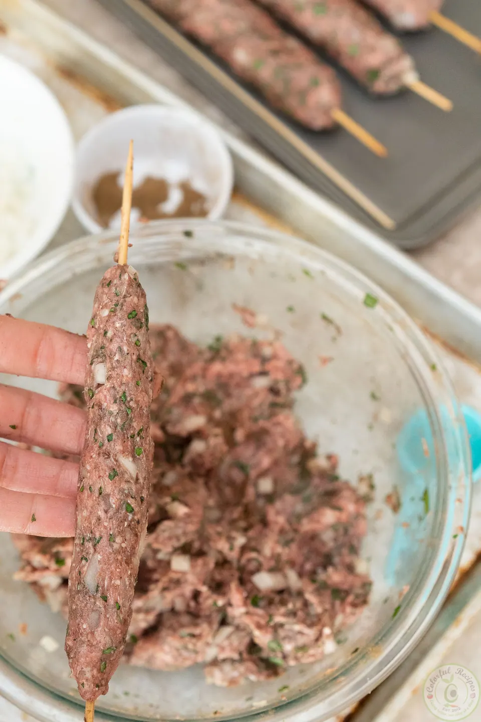 Forming a long lamb kafta finger tightly around a skewer