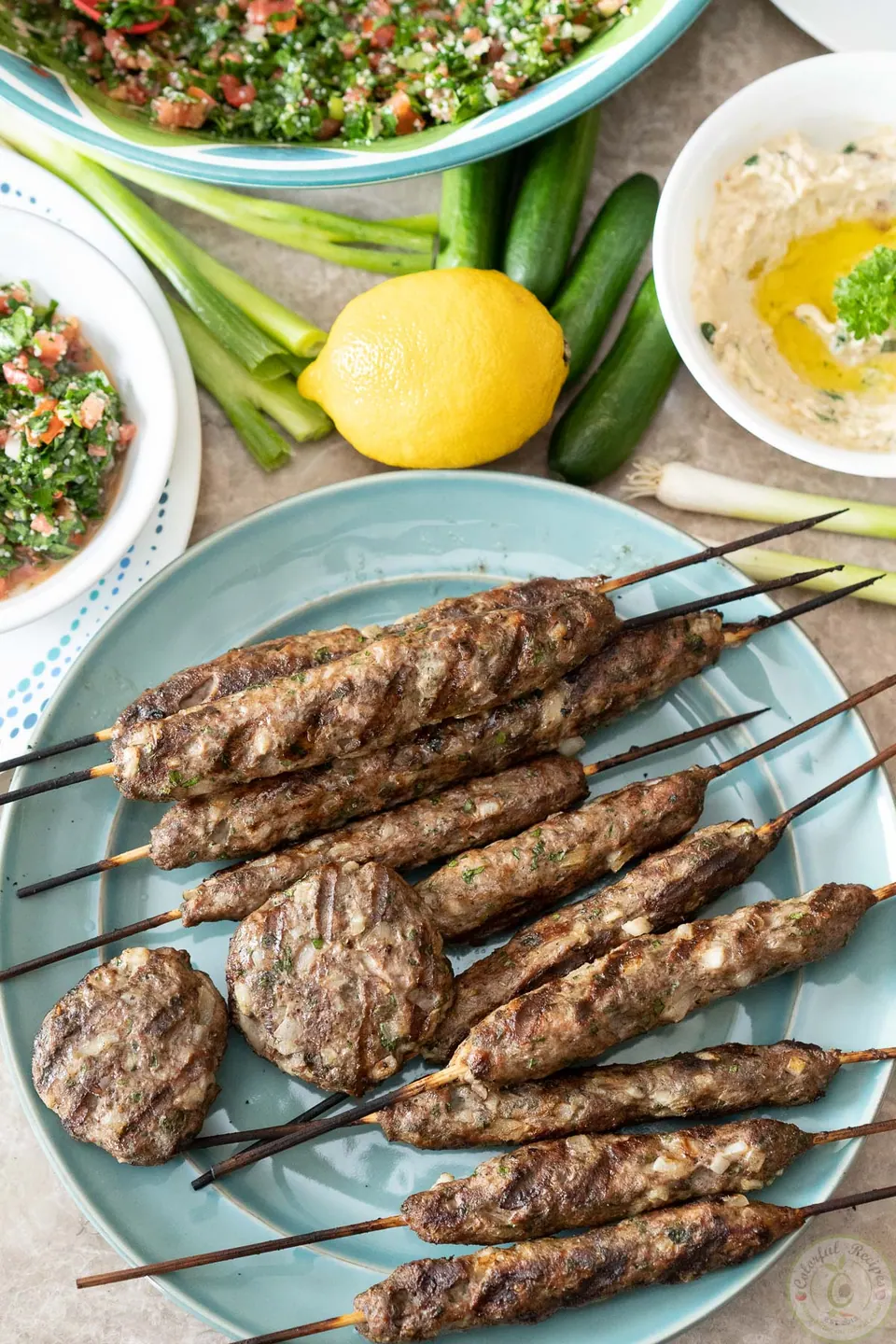 Platter of grilled lamb kafta kabobs and patties served with tabbouleh and lemon