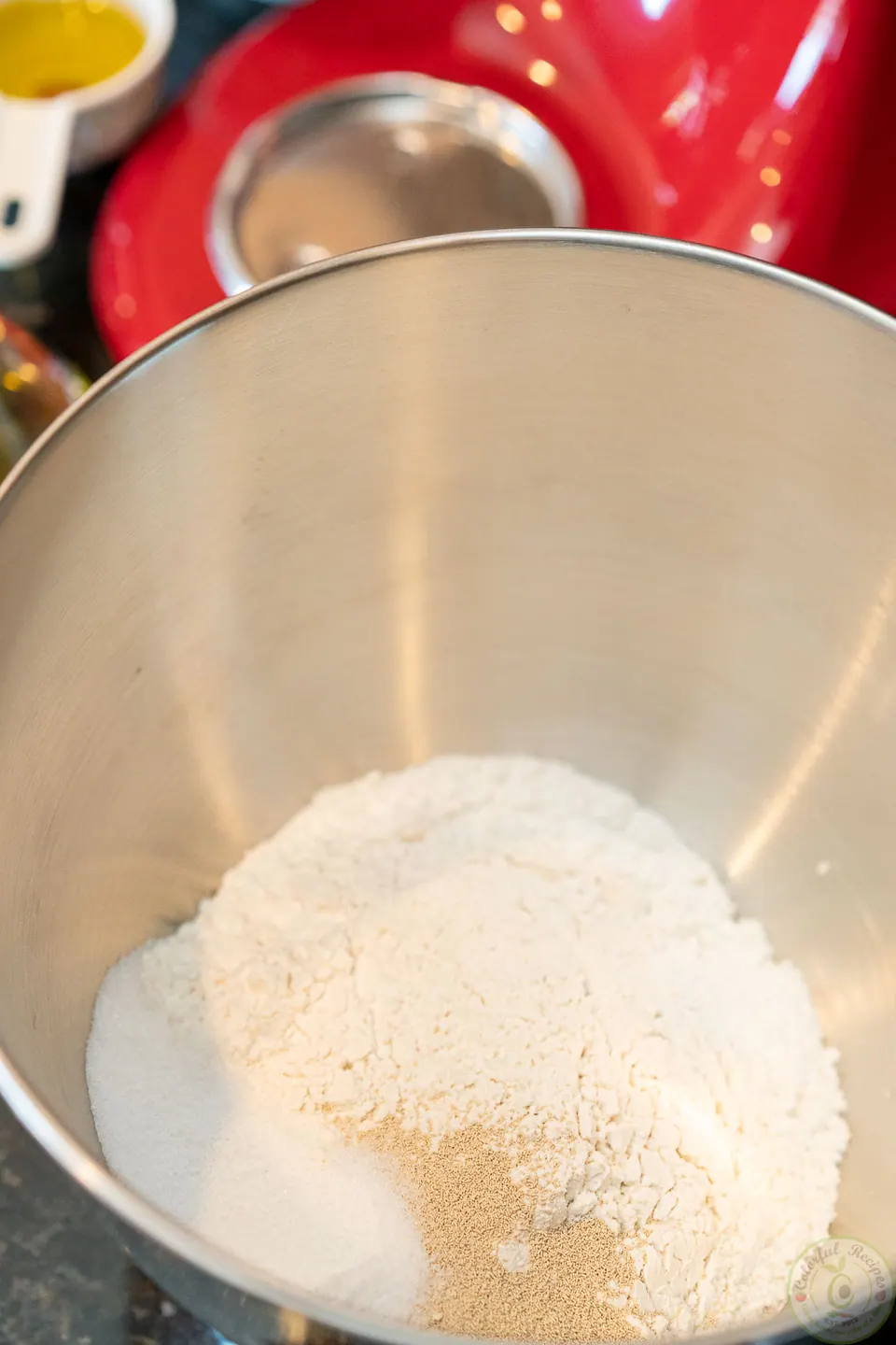 Flour and dry ingredients for easy pizza dough in a stand mixer bowl