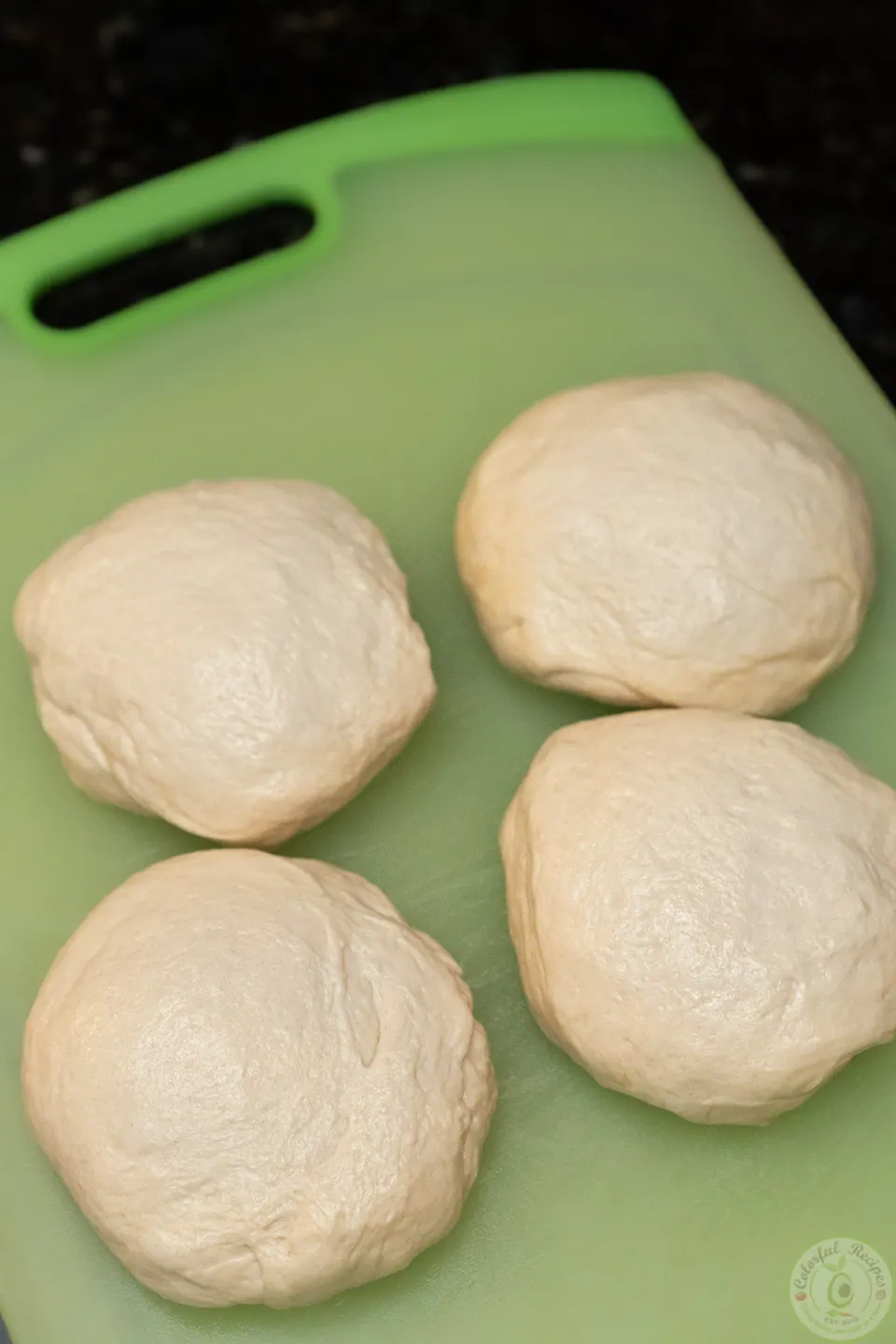 Four balls of easy pizza dough on a cutting board