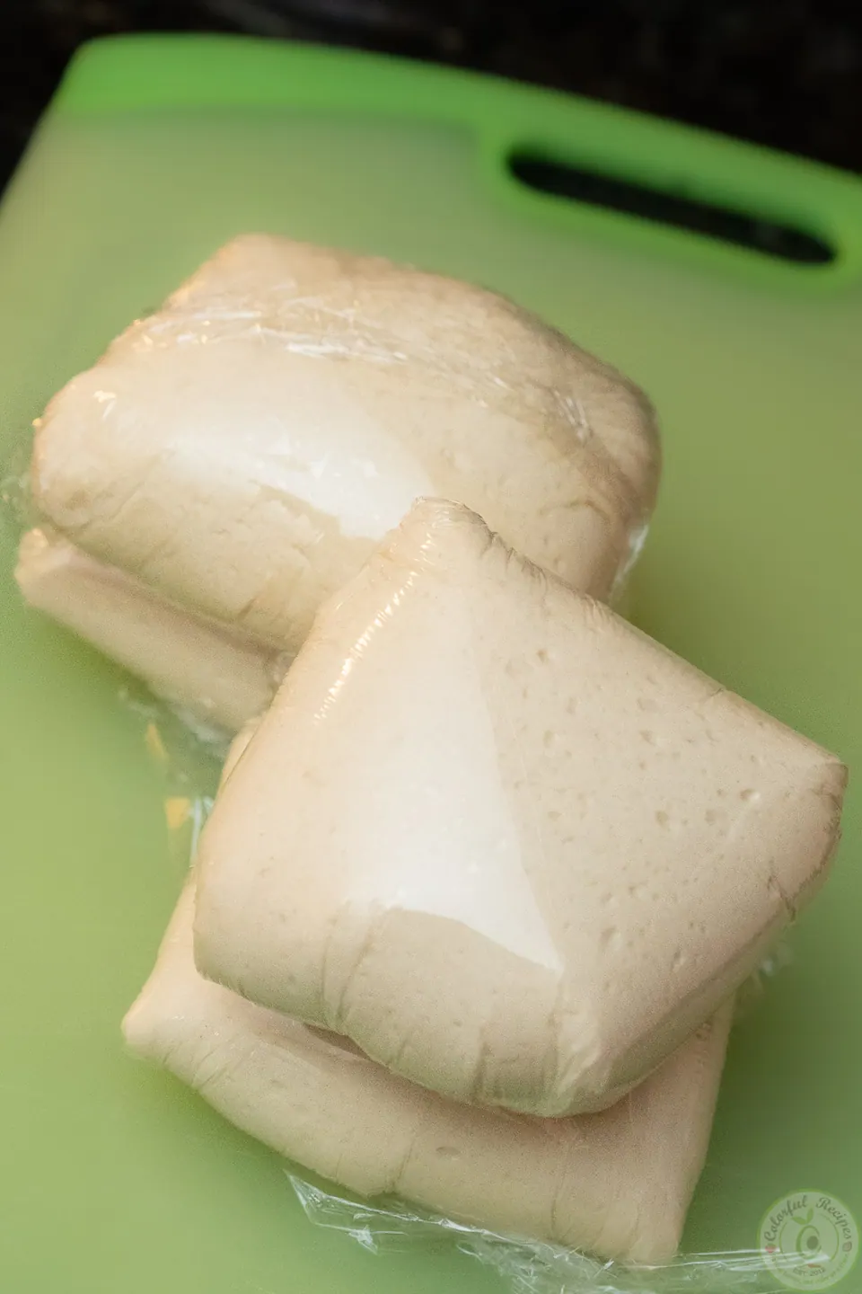 Pizza dough balls wrapped in plastic wrap for storing