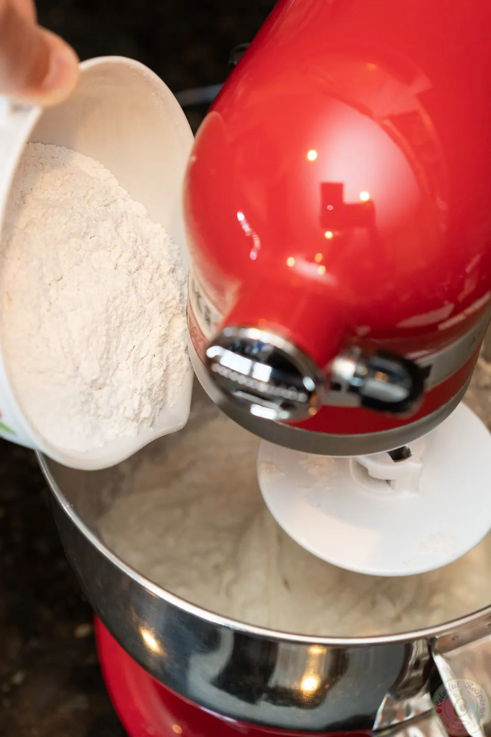Adding flour gradually to pizza dough in a KitchenAid mixer