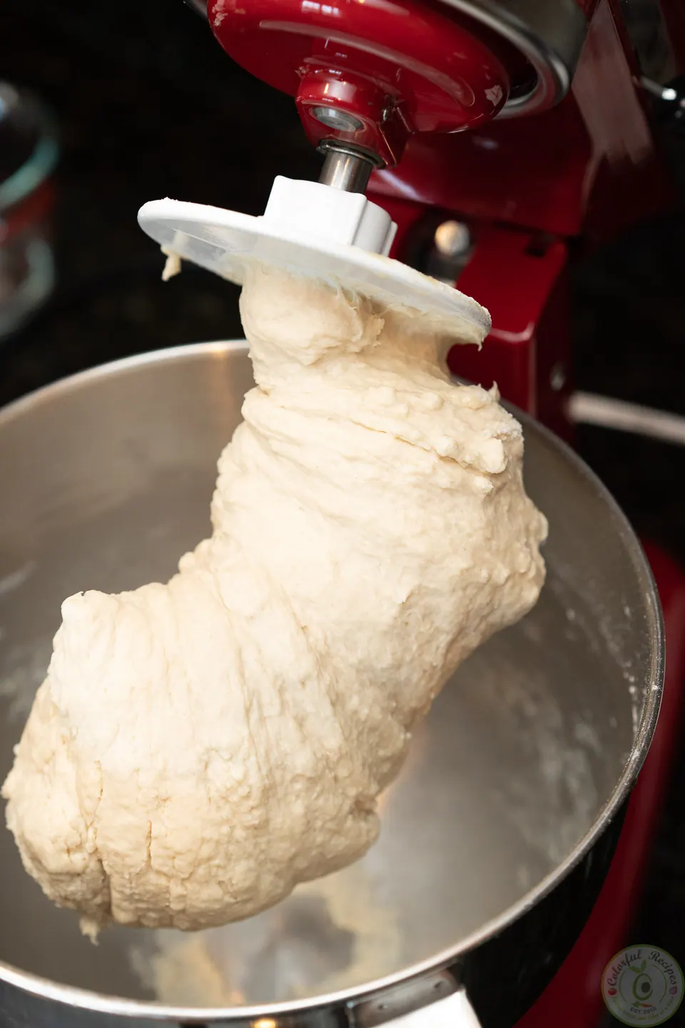Elastic pizza dough on the dough hook of a stand mixer