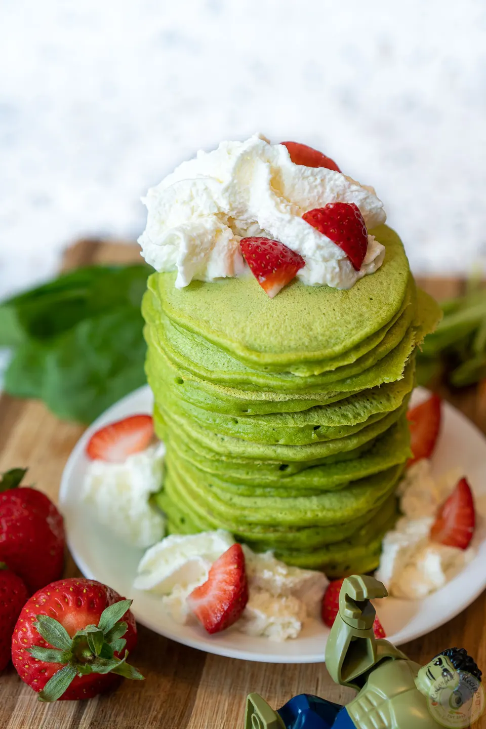 Light green pancakes with spinach on a griddle