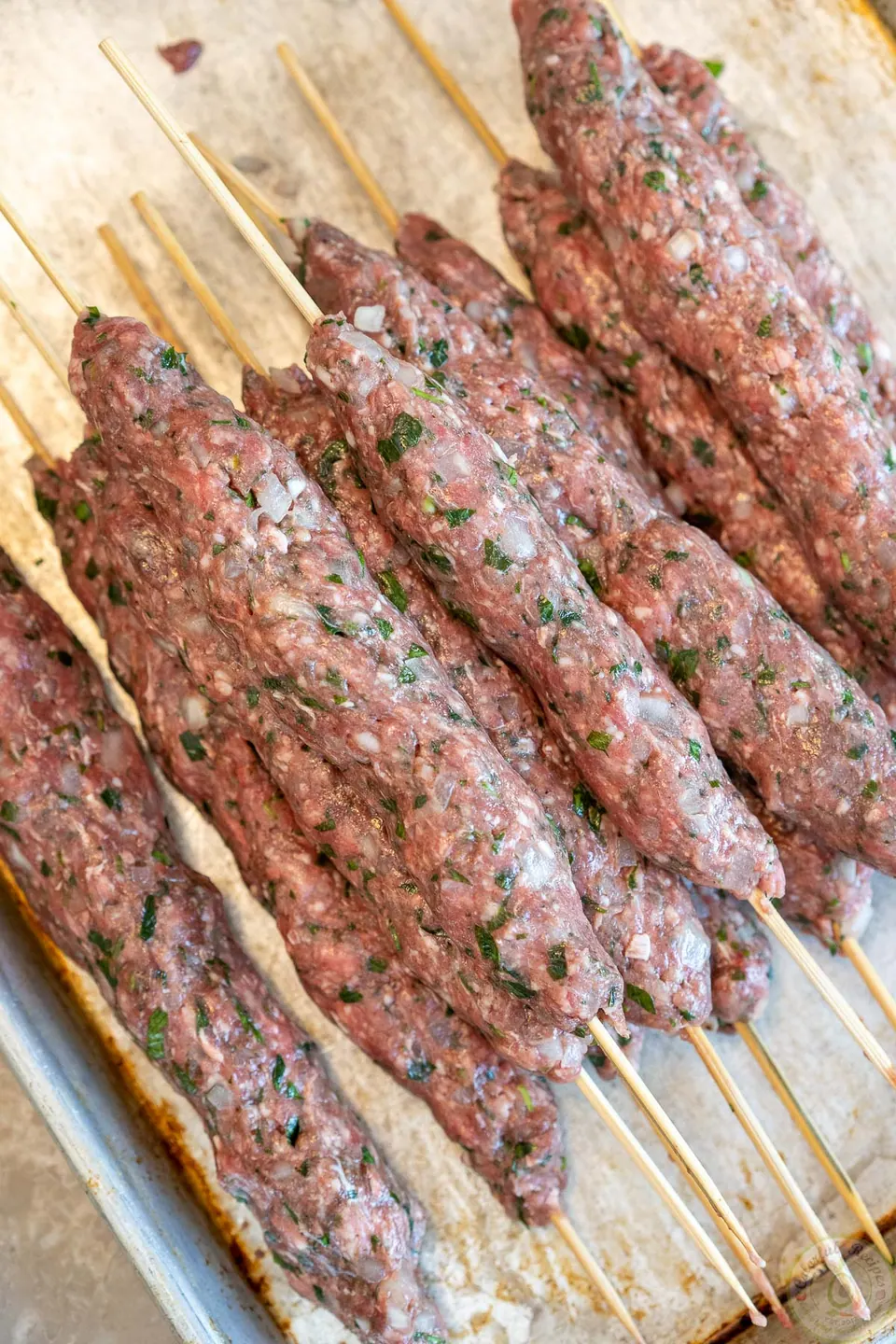 Raw lamb and beef kafta formed around skewers