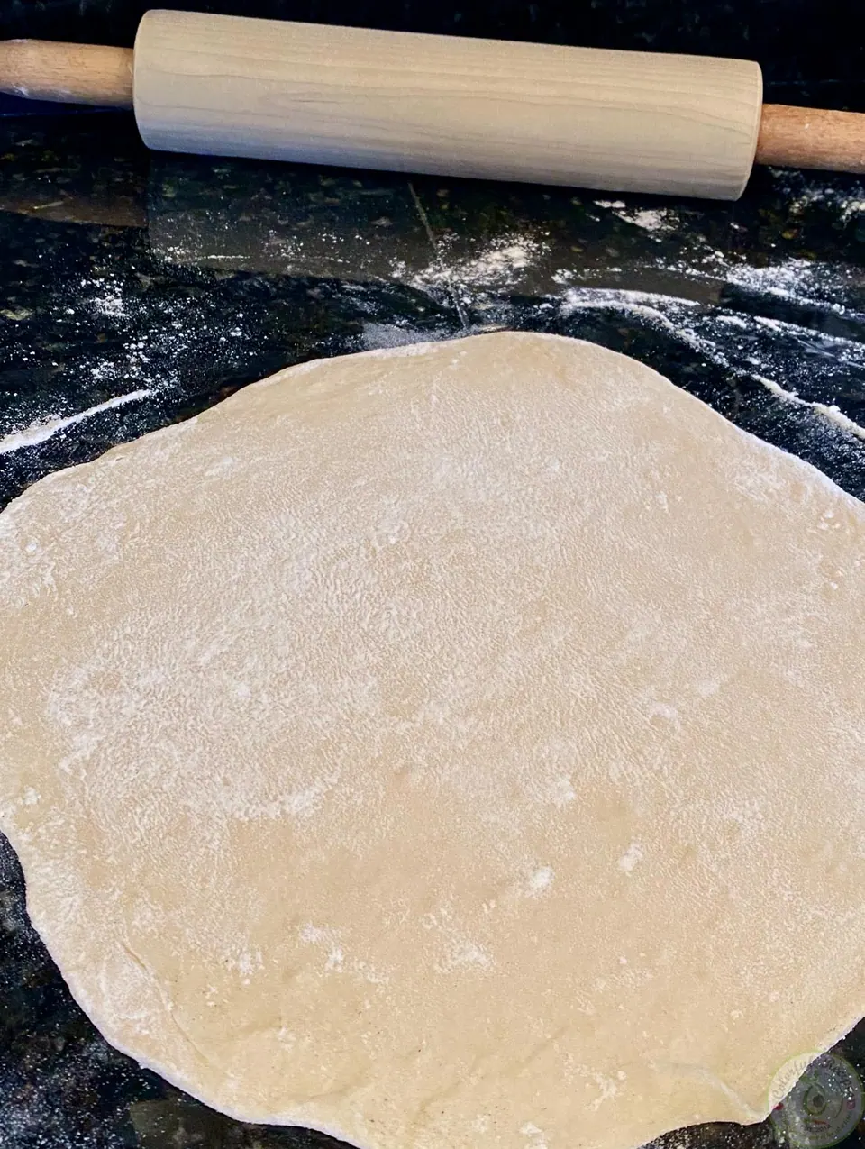 Mankousheh dough rolled into a circle with a rolling pin