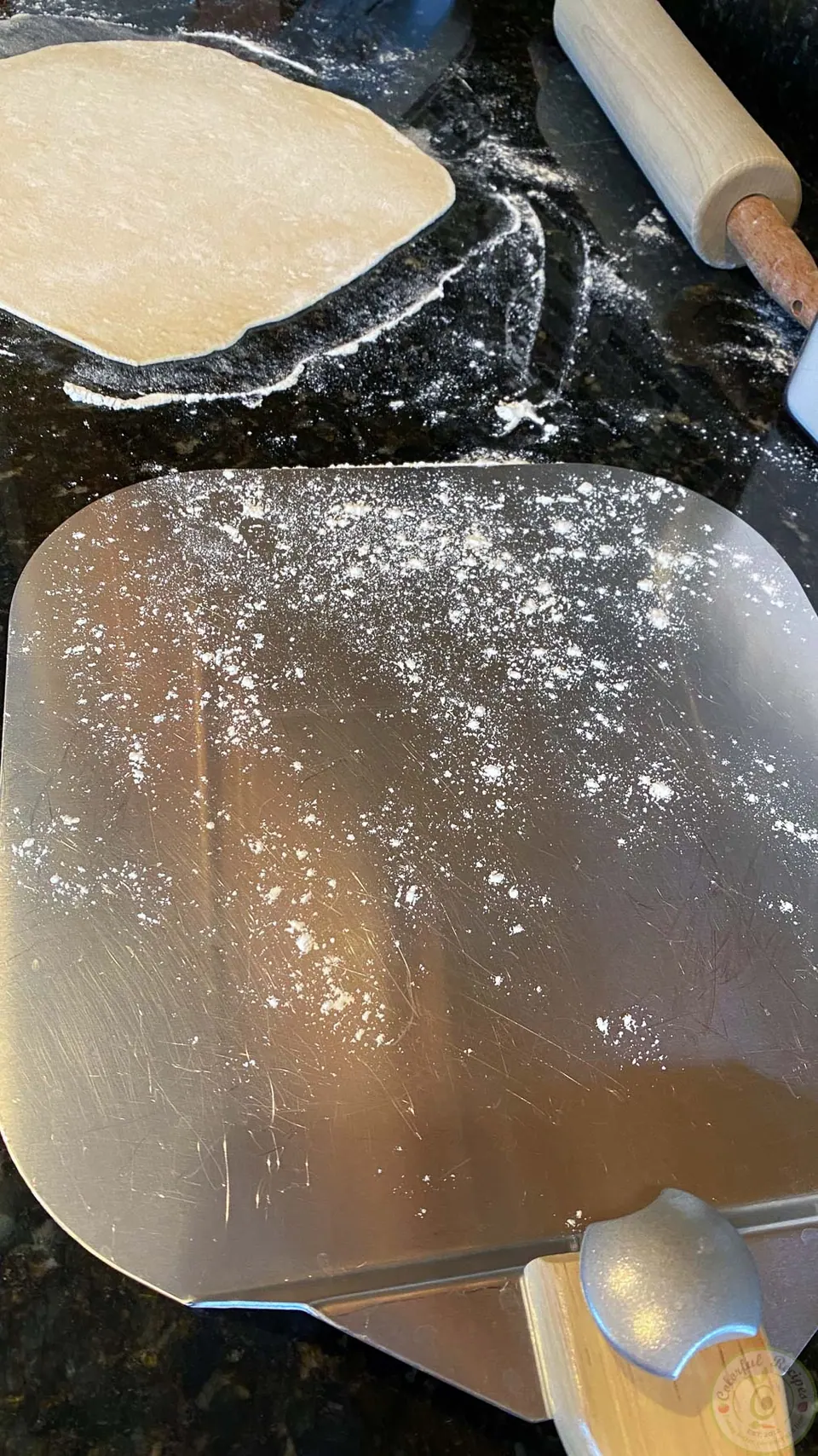 Floured pizza peel next to rolled mankousheh dough