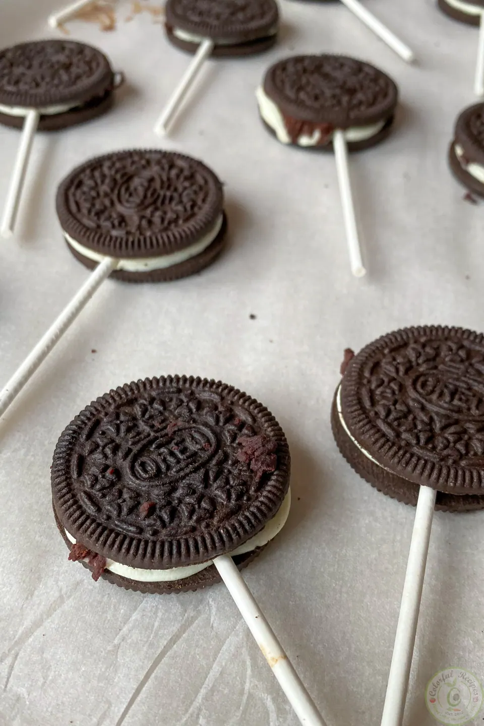 Oreo cookies closed around lollipop sticks before dipping