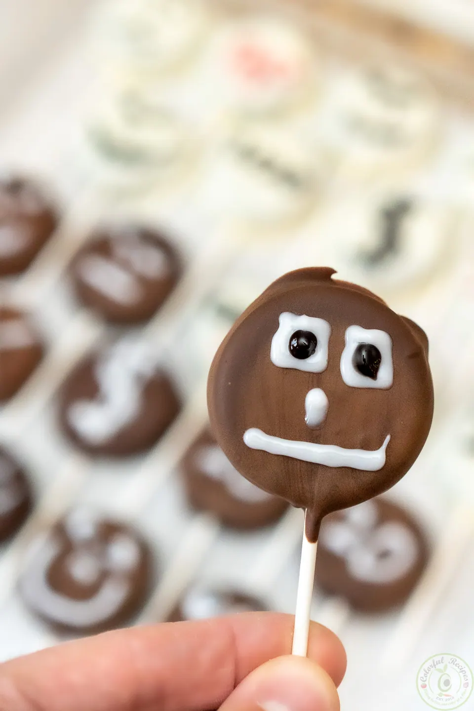 Chocolate-dipped Halloween Oreo pop with a funny icing face