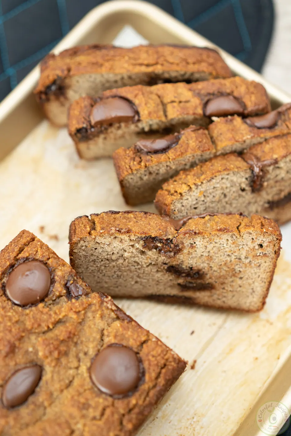 Sliced almond flour banana bread topped with melted milk chocolate wafers