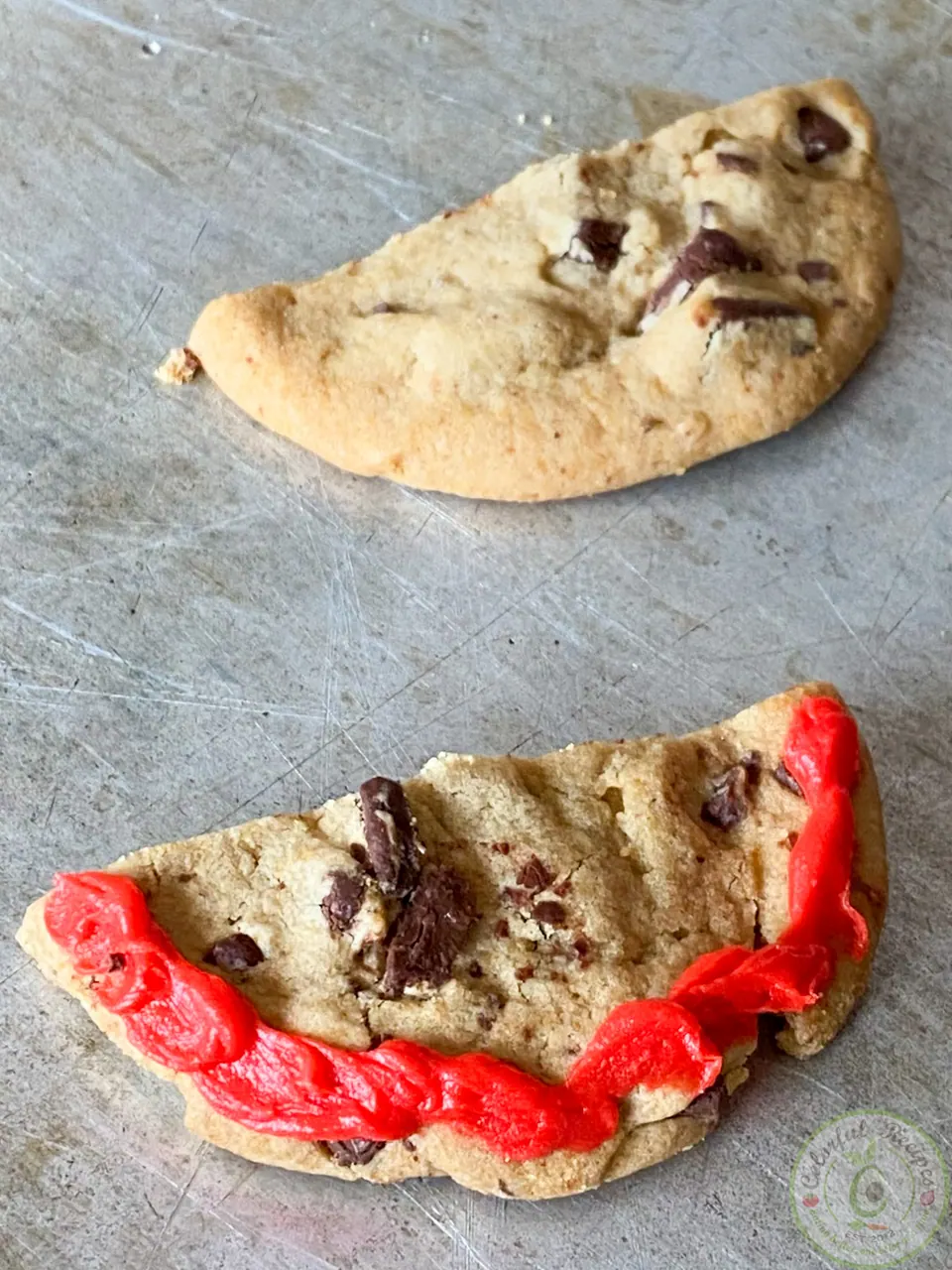 Cookie half with red decorating gel piped along the rim