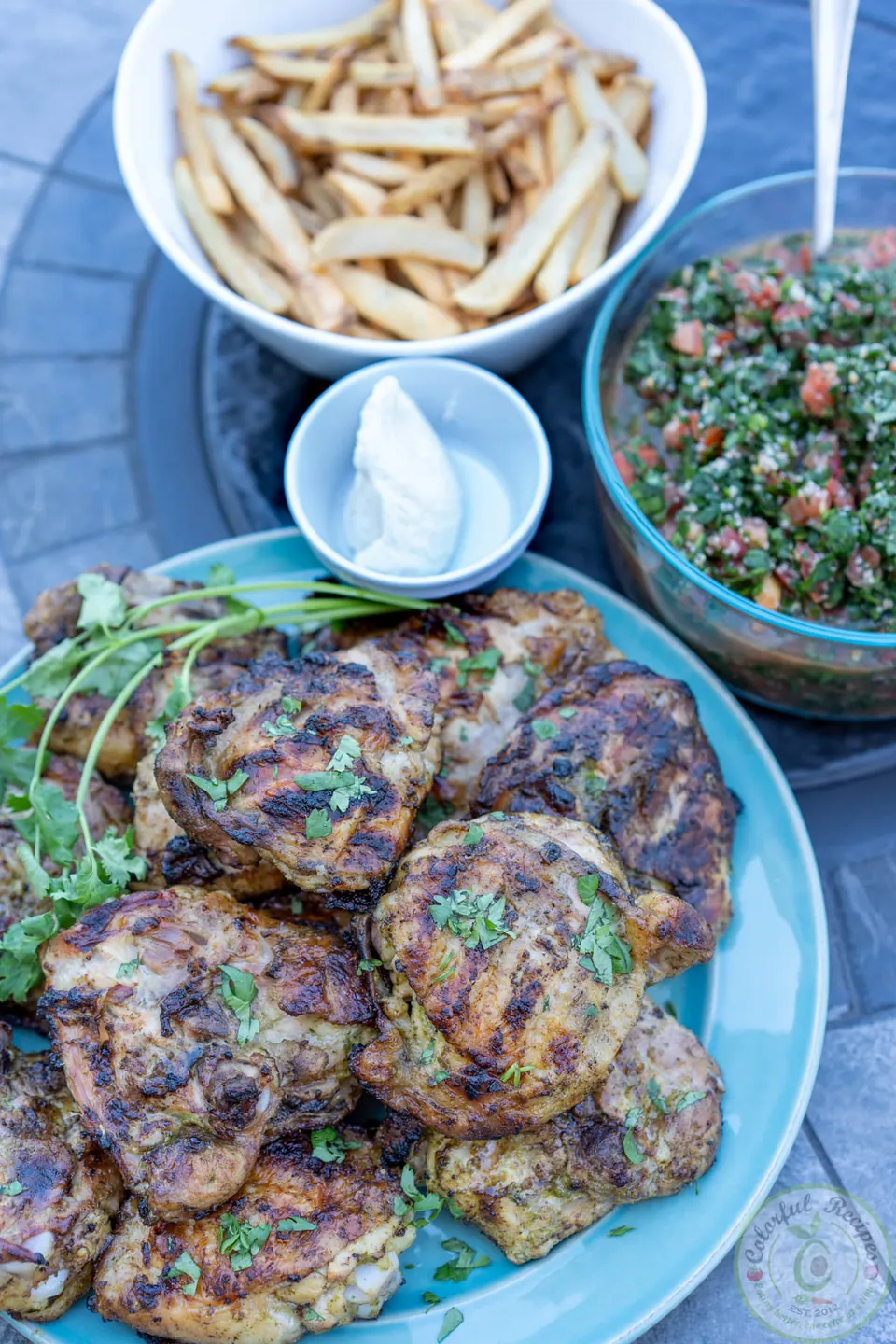Platter of cilantro lemon garlic grilled chicken thighs garnished with lemon
