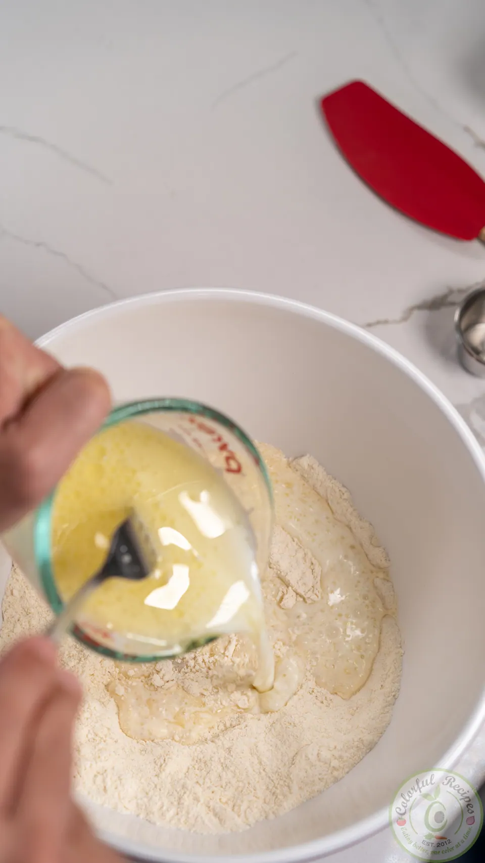 Pouring milk into manakish dough