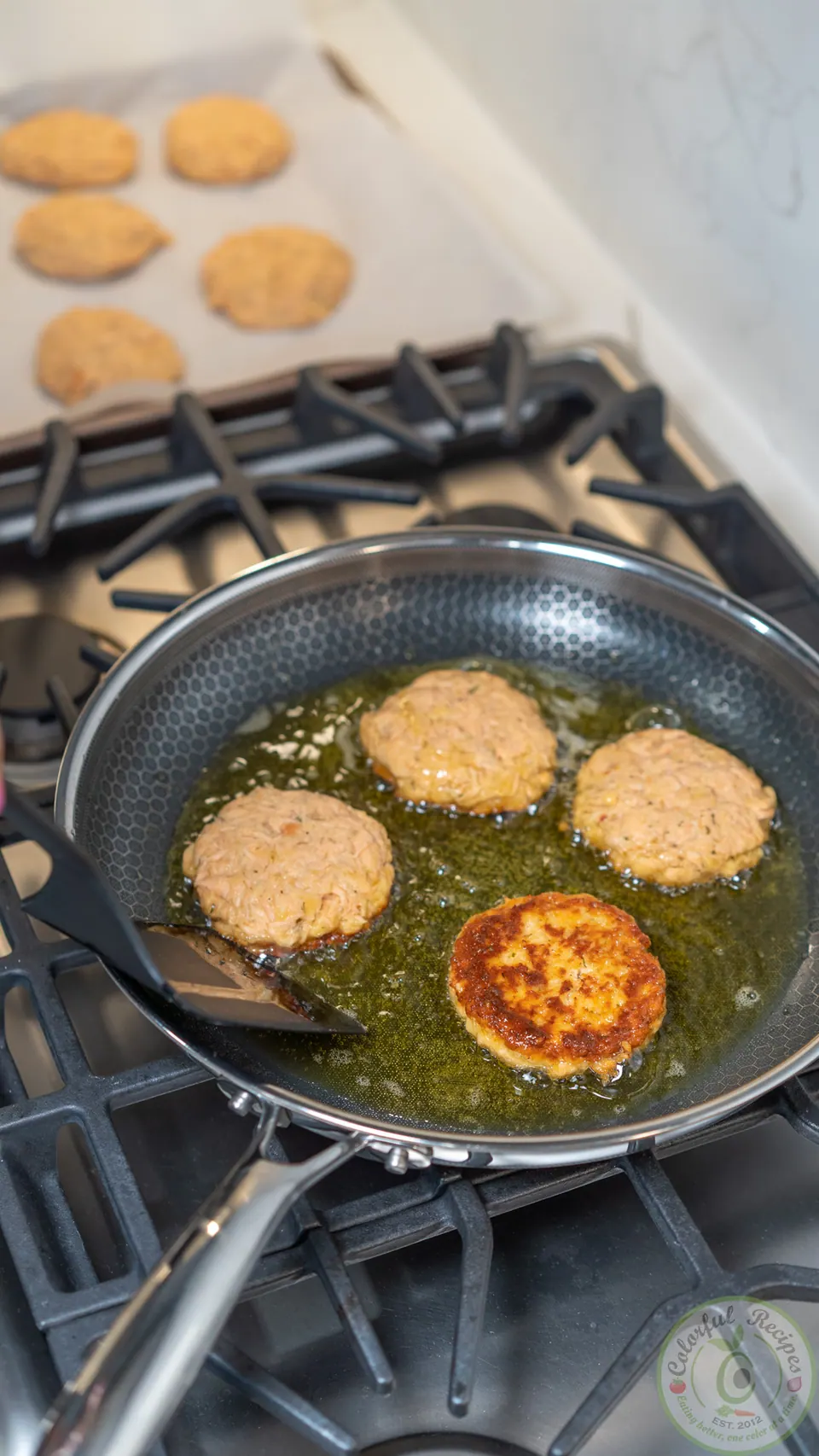 Salmon patties frying in olive oil