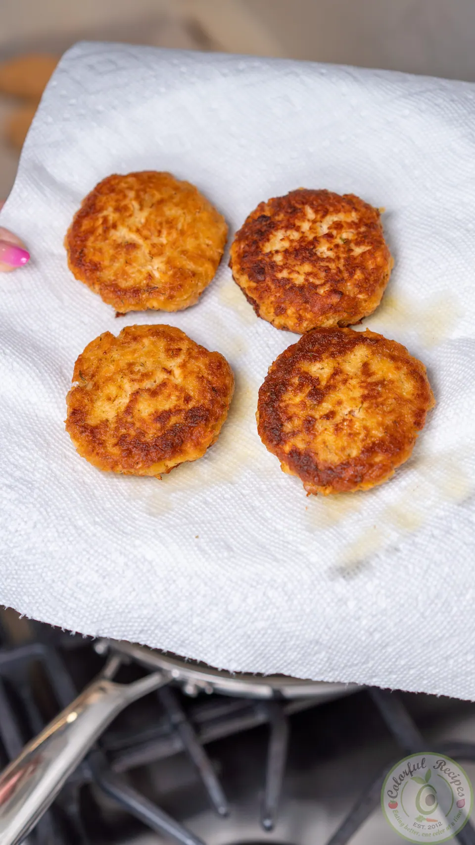 Salmon patties draining on paper towel