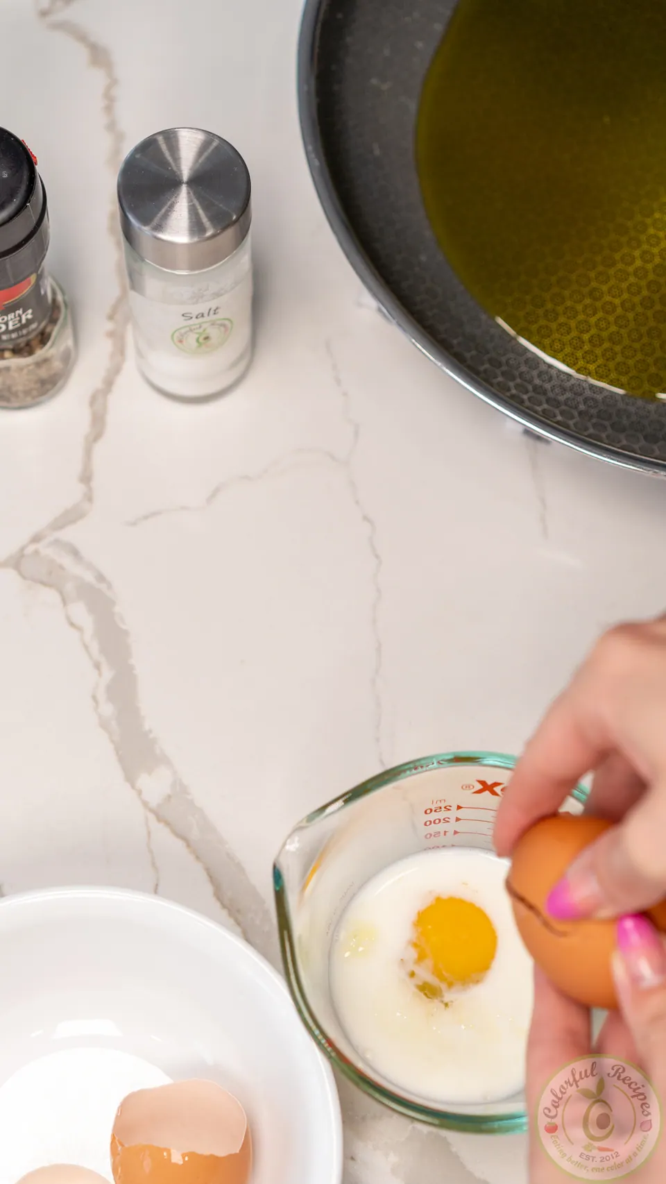 Cracking eggs into milk for salmon patties