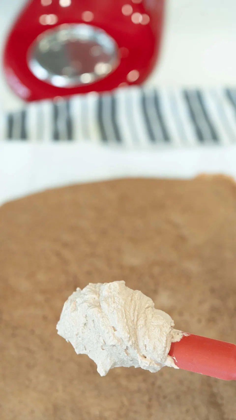 Spatula of Nutella whipped cream over the Yule Log sponge cake