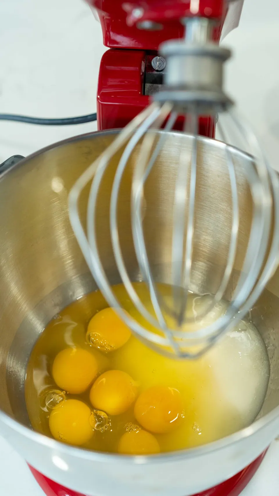 Eggs in a stand mixer bowl ready to whip for the Yule Log sponge cake
