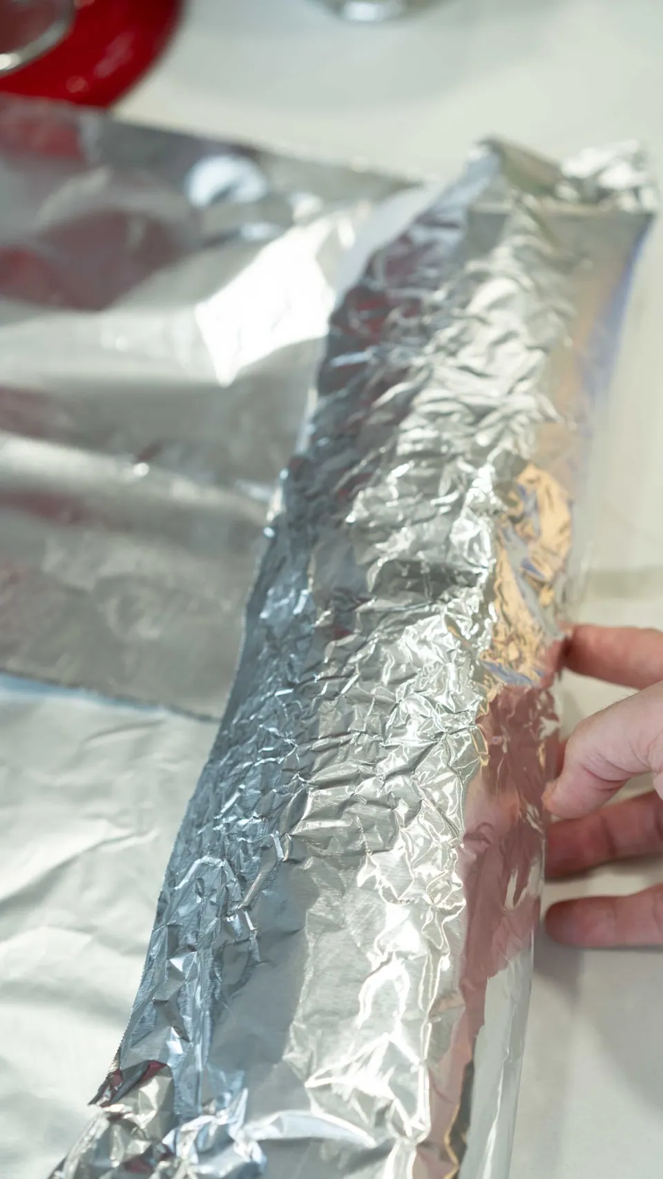 Wrapping the rolled Yule Log cake in foil before freezing
