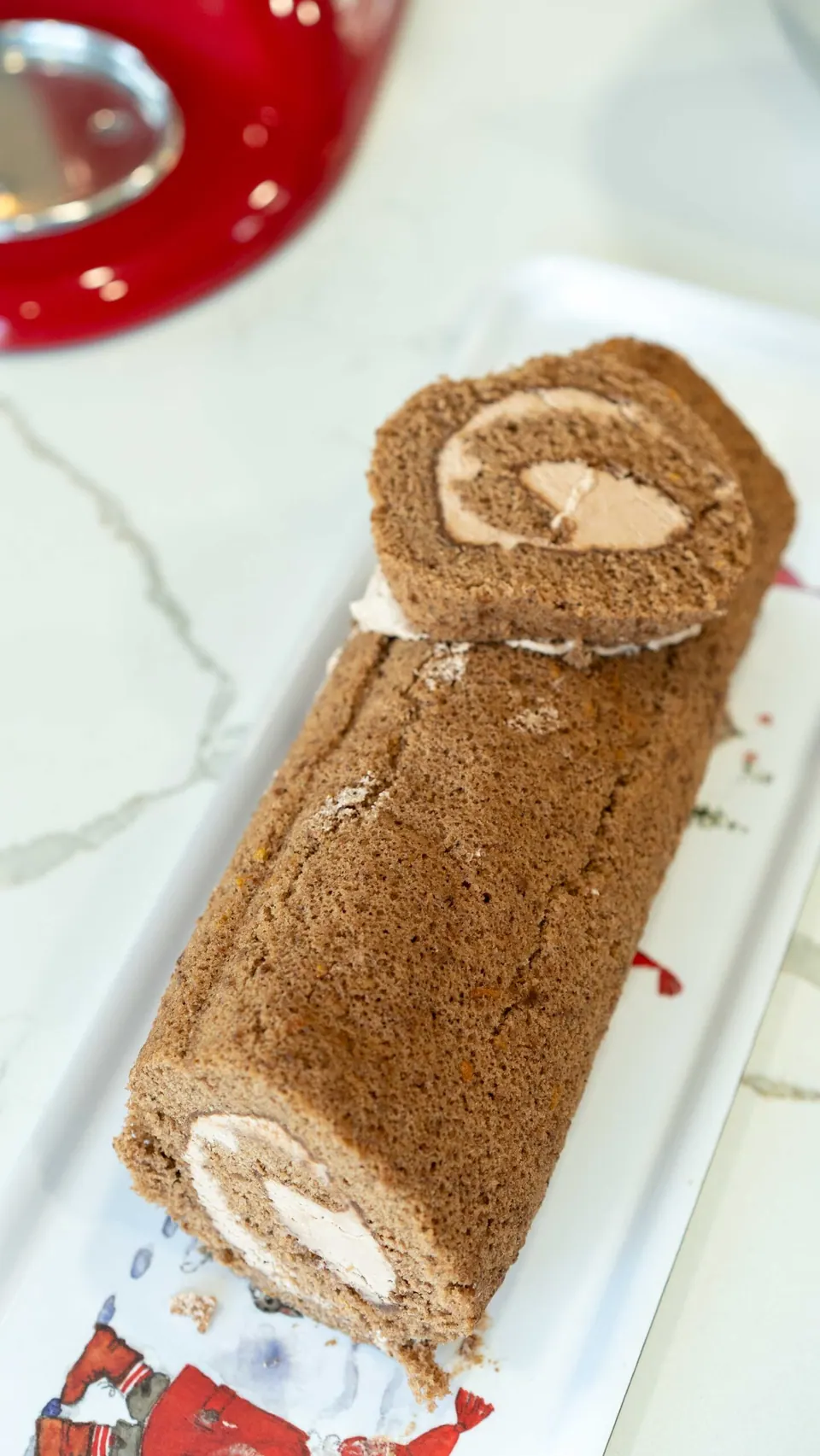 Trimmed Yule Log cake with a cut end placed on top as a branch