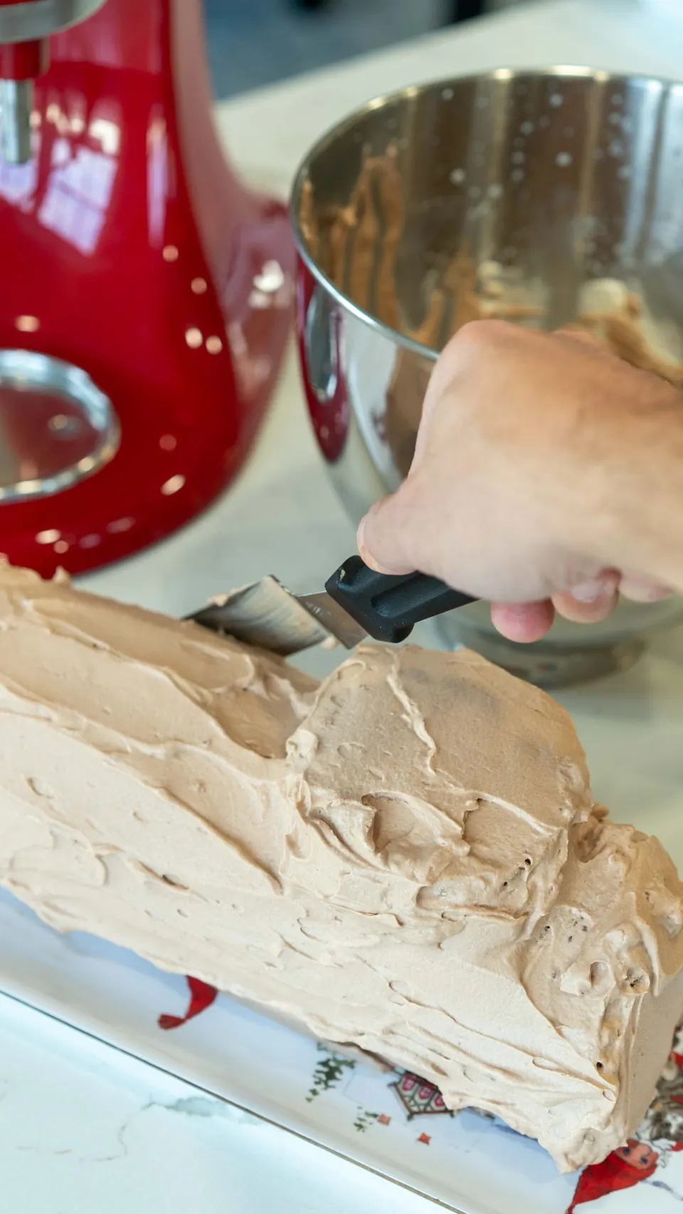 Frosting the Christmas Yule Log cake with Nutella whipped cream
