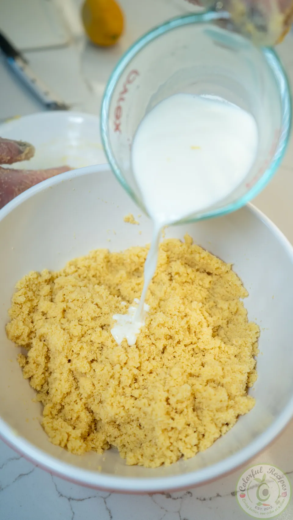 Pouring warm milk into the semolina maamoul dough