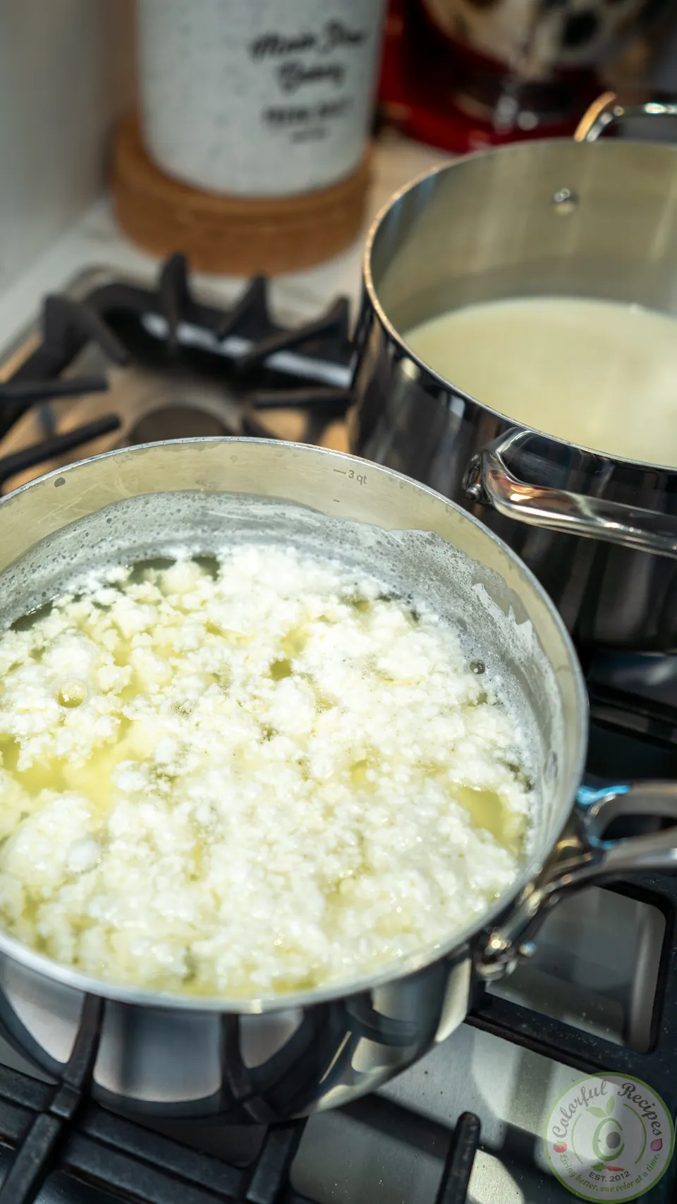 Milk separating into clotted ashta curds in a saucepan