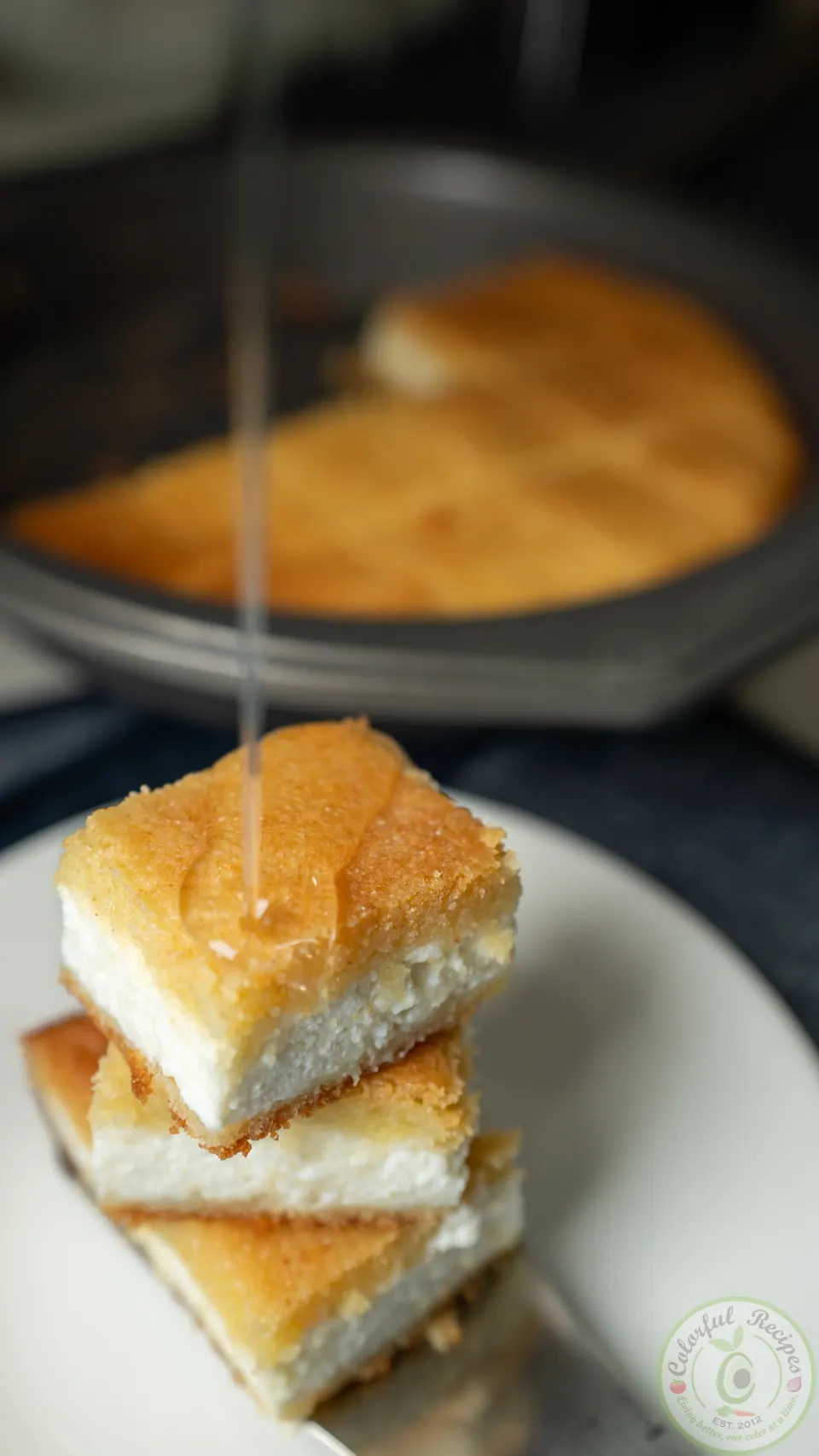 Stack of Maamoul Mad bi Ashta squares drizzled with sugar syrup