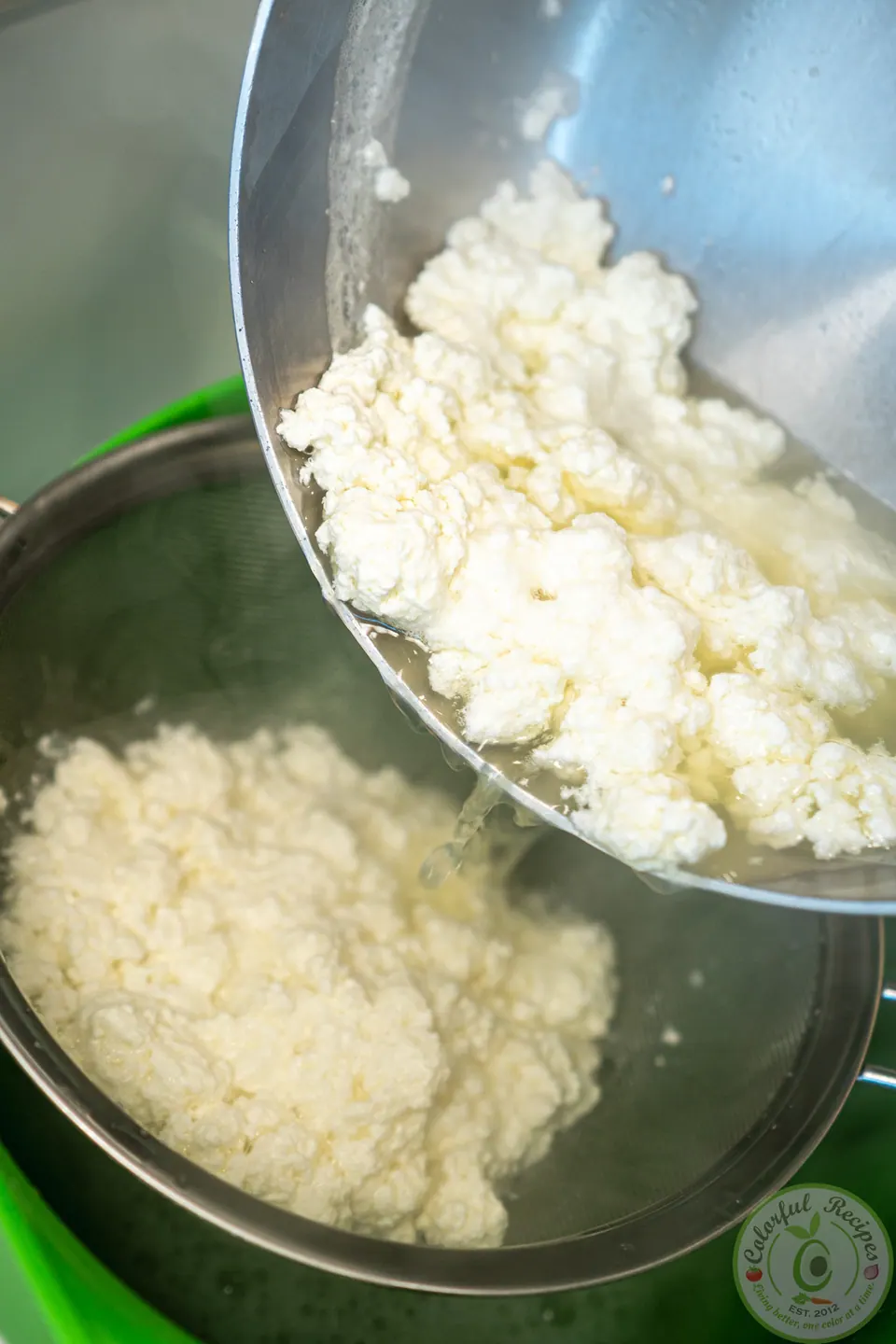 Pouring clotted ashta curds into a strainer