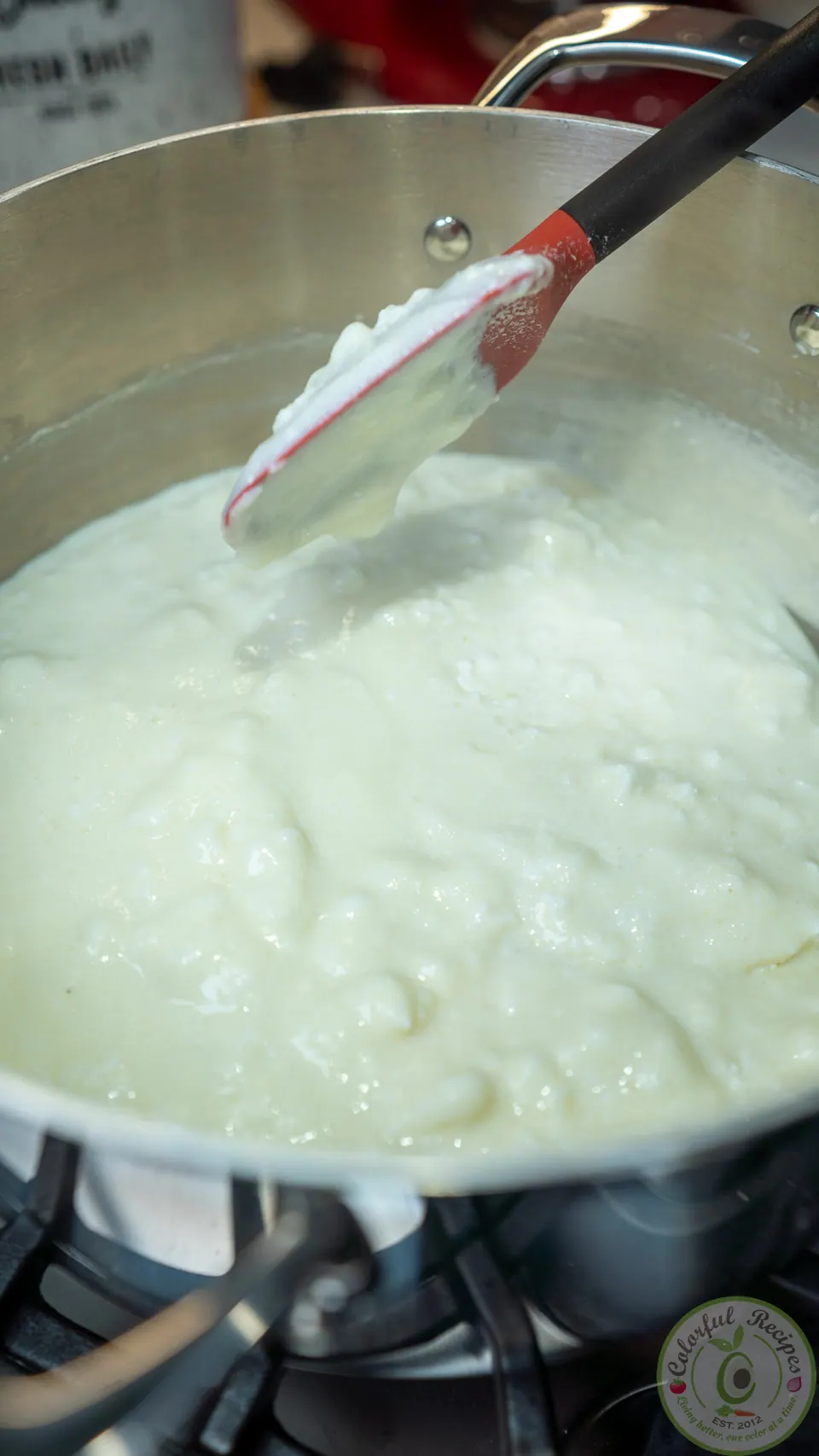 Stirring the combined ashta filling with a spatula