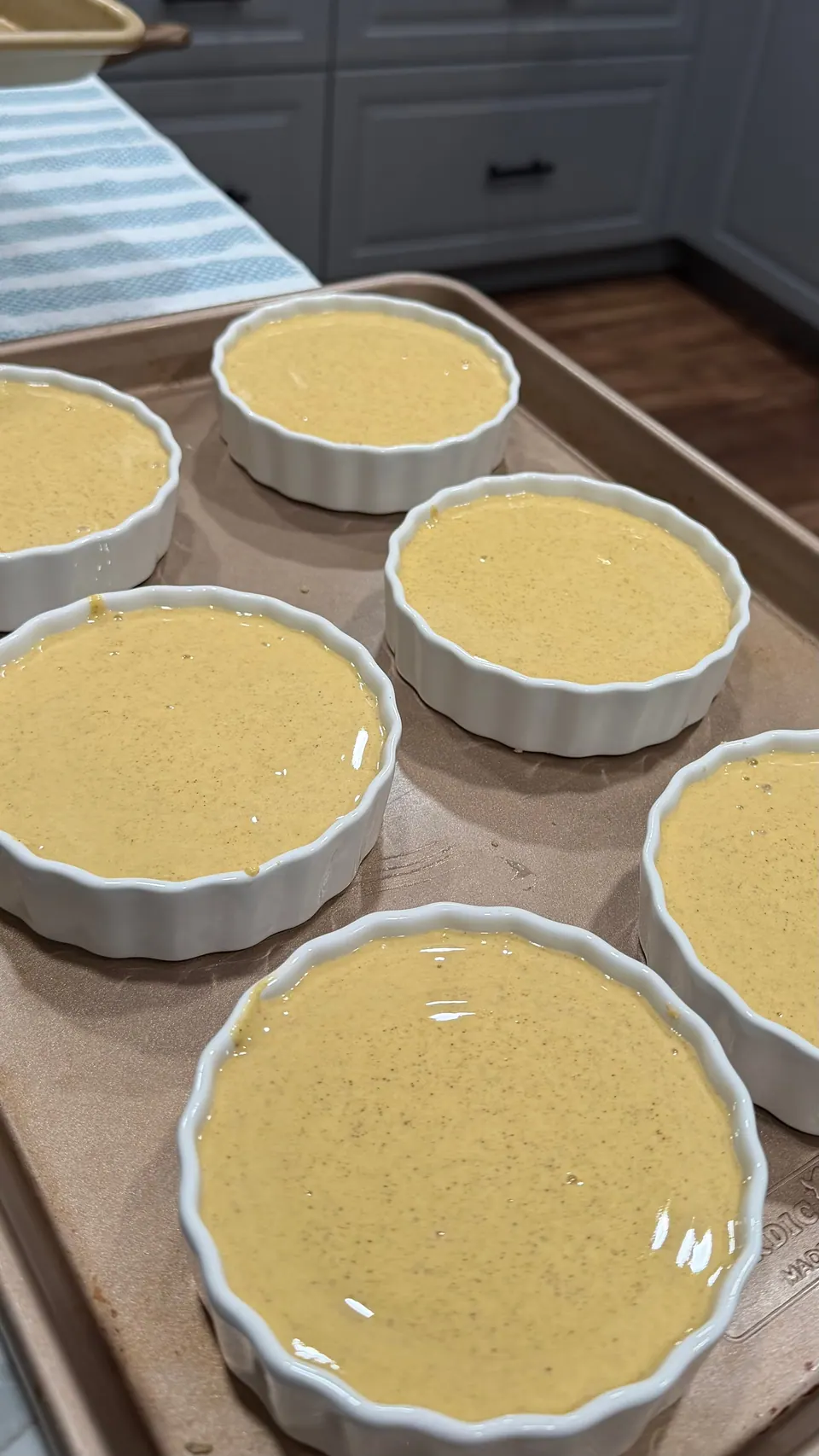 Six ramekins filled with cottage cheese pumpkin pie filling, ready to bake