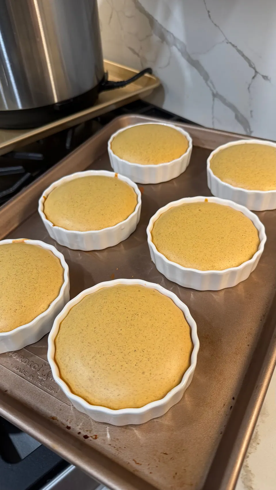 Six healthy cottage cheese pumpkin pies cooling on a baking sheet