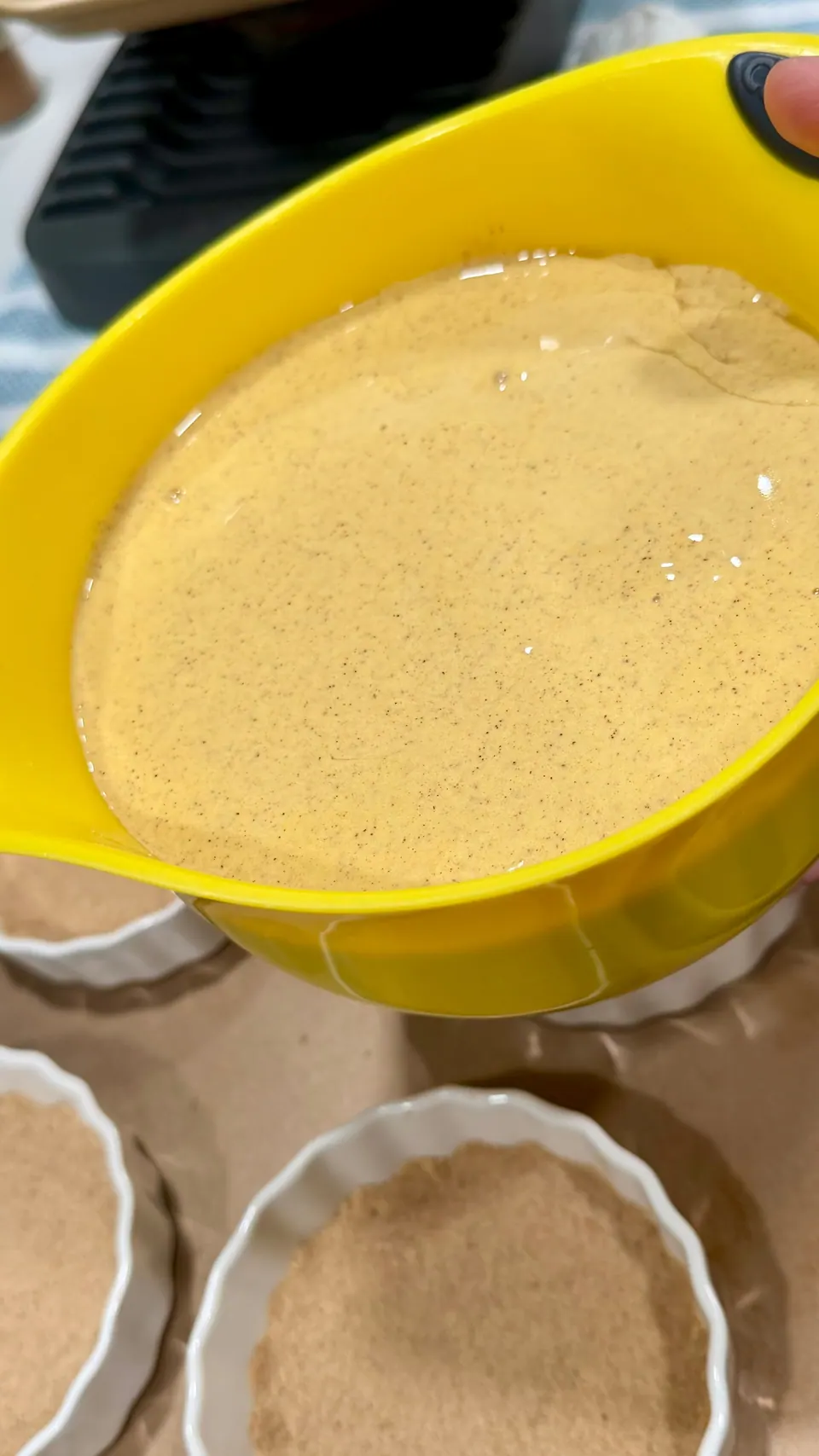 Blended high-protein cottage cheese pumpkin pie filling next to ramekins with almond protein crust